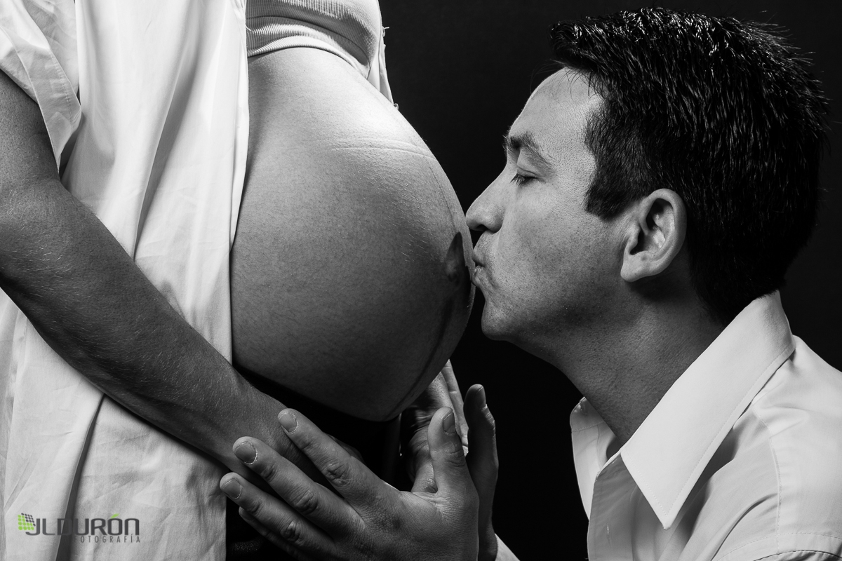 Padre amoroso besa vientre de esposa embarazada
